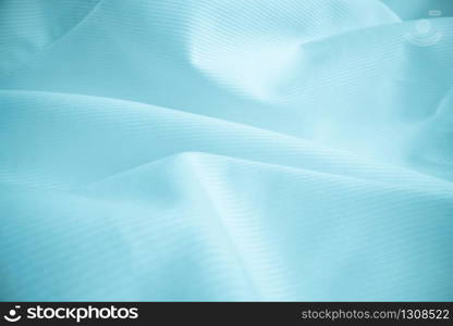 Shiny flowing cloth texture in macro shot. Wavy clean silk weave material. Textile abstract background.
