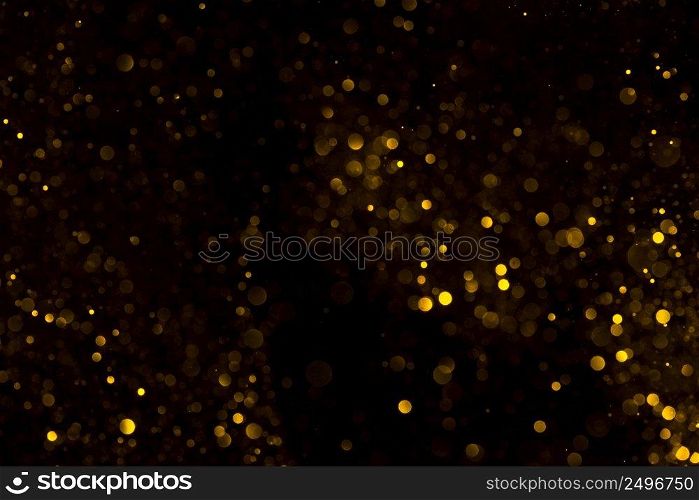 Shiny gold glitter bokeh on black background