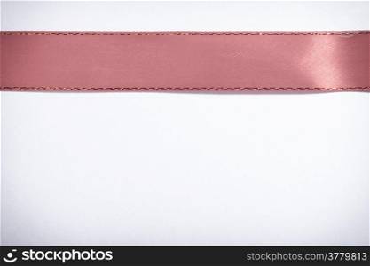 Shiny red ribbon on white background with copy space. Greeting card note or blank sale tag.