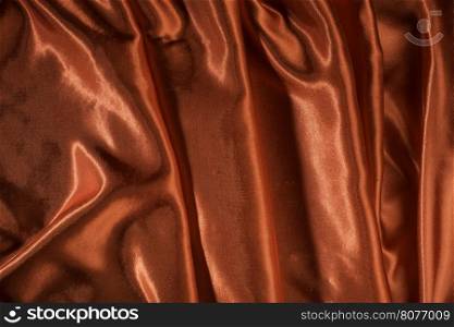 Shiny red satin pleated fabric background. Close up