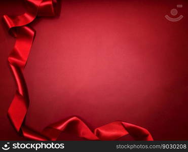 Shiny red satin ribbon on red paper background. Valentines day flat lay copy space.