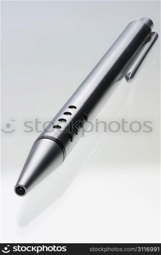 Shiny steel ball-point pen and its reflection in the glass surface, hyper DoF.