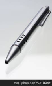 Shiny steel ball-point pen and its reflection in the glass surface, hyper DoF.