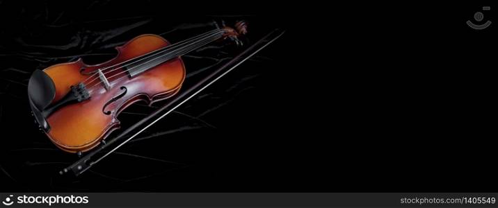 Shiny violin and bow isolated on black velvet background with copy space