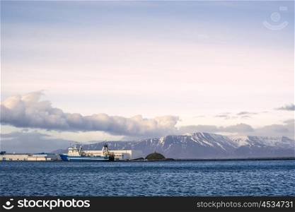 Ship by the harbor in Reykjavik with a mountain in the background