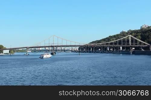 ship floats under Parkovy Bridge over Dnieper, Kiev, Ukraine