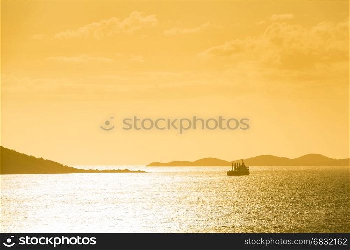 Ship silhouetted at sunset off the coast of Noumea, New Caledonia