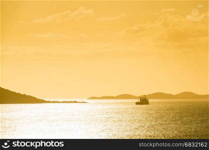 Ship silhouetted at sunset off the coast of Noumea, New Caledonia