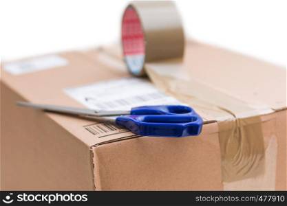 Shipping concept: Cardboard box, scissors and sticky tape