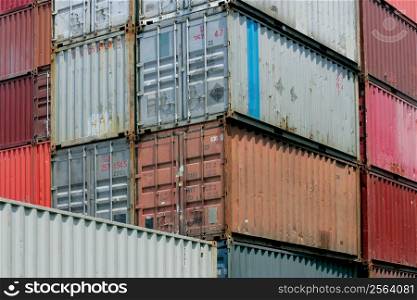 Shipping containers waiting to be loaded on a cargo ship. Numbers and markings have been altered to have no meaning or reference.
