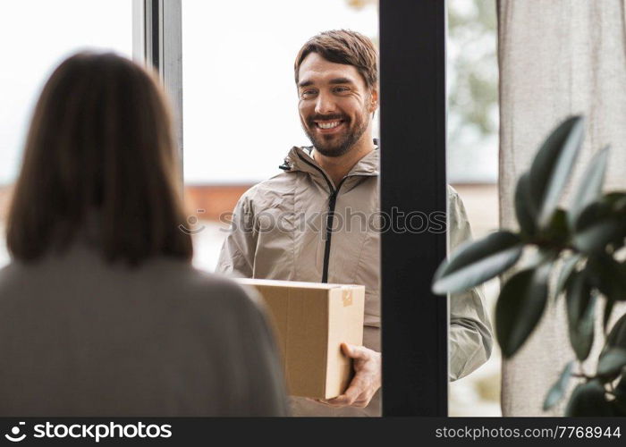 shipping, transportation and people concept - delivery man with parcel box and customer at home. delivery man with parcel box and customer at home