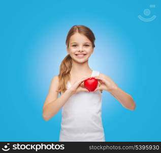 shirt design, health, charity, love concept - smiling teenage girl in blank white shirt with small red heart