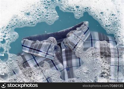 Shirt soak in powder detergent water dissolution, washing cloth. Laundry concept