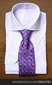 shirt with violet tie on wooden shelf