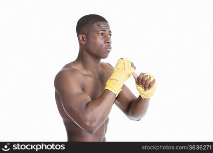 Shirtless African American kickboxer over gray background