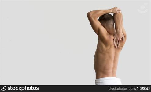 shirtless man stretching his arms with copy space