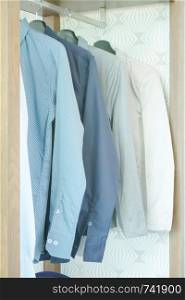 Shirts and men's suit hanging in closet