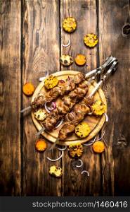 Shish kebab with grilled vegetables. On wooden background.. Shish kebab with grilled vegetables.