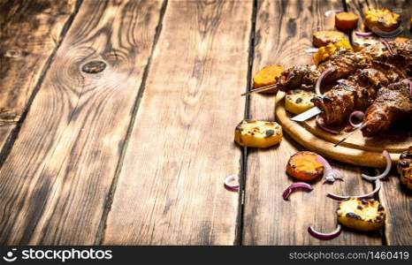 Shish kebab with grilled vegetables. On wooden background.. Shish kebab with grilled vegetables.