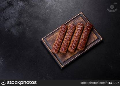 Shish kebab with vegetables on black concrete background. Grilled kebab with spices and herbs on a dark concrete background