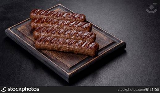 Shish kebab with vegetables on black concrete background. Grilled kebab with spices and herbs on a dark concrete background
