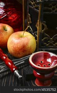 Shisha and apple. Smoking hookah tobacco with apple aroma and stylish Arabic lantern