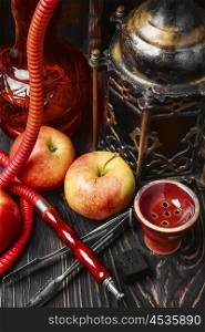 Shisha and apple. Smoking hookah tobacco with apple aroma and stylish Arabic lantern