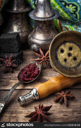 Shisha hookah with anise flavor. Mouthpiece of hookah and spoon with tobacco with anise flavor