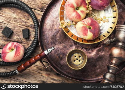 Shisha hookah with peach. Smoking Turkish hookah with tobacco with peach flavor