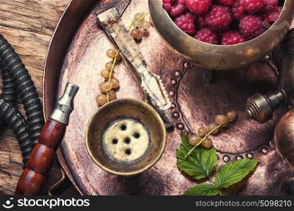 Shisha hookah with raspberries. Smoking Turkish hookah with tobacco with raspberry flavor