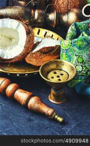 Shisha with coconut taste. Stylish oriental shisha and ripe tropical coconut