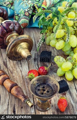 Shisha with fruity aroma. Hookah with fruit flavour on wooden table in vintage style