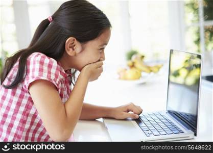 Shocked Asian Child Using Laptop At Home