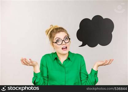 Shocked astonished business woman wearing green shirt with black thinking or speech bubble.. Shocked business woman with thinking bubble