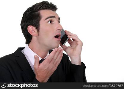 Shocked businessman with mobile telephone