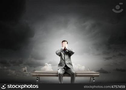 Shocked businessman. Young shocked businessman sitting on wooden bench