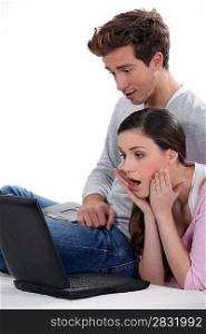 Shocked couple looking at laptop