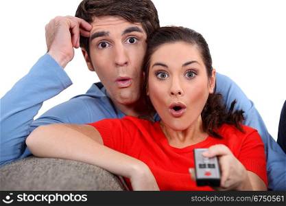 Shocked couple watching television
