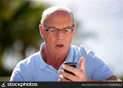 Shocked old man reading text message