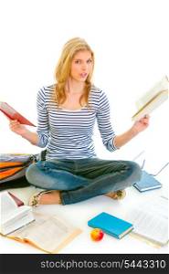 Shocked teen girl sitting on floor with books and preparing for exams isolated on white &#xA;