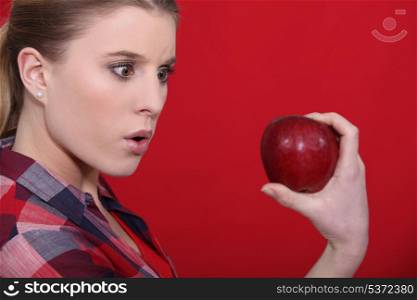 Shocked woman holding apple
