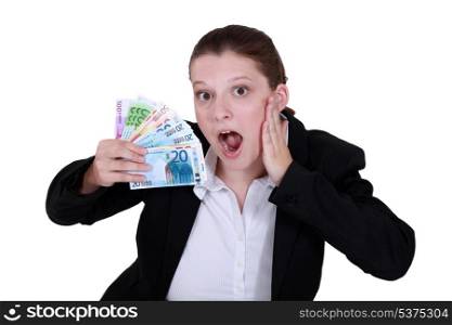 Shocked woman holding cash