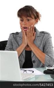 Shocked woman looking at computer screen