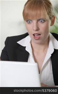 Shocked woman looking at laptop
