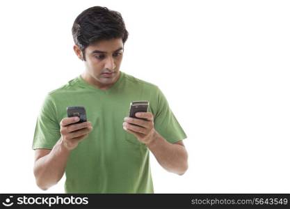 Shocked young man reading text message over white background