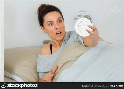 shocked young woman waking up with alarm