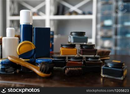 Shoe care products, polish, wax and creams footwear repair service. Shoemaking workshop, bootmaker tools and equipment on the table, cobbler job