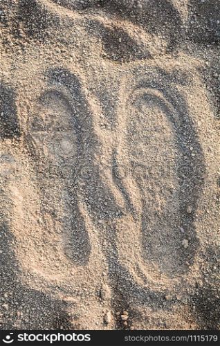 Shoe track on sand / Imprint footprint on ground traces of feet texture background