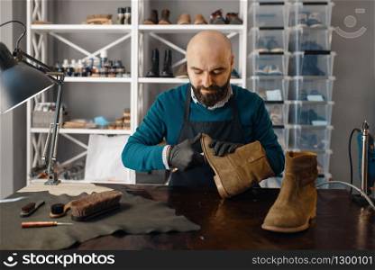 Shoemaker fix the shoe, footwear repair. Craftsman skill, shoemaking workshop, master works with boots, cobbler job