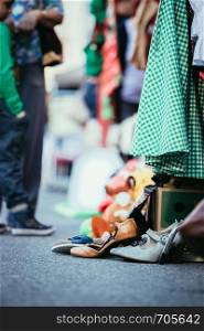 Shoes, dresses and stuff on a flea market, people in the blurry background